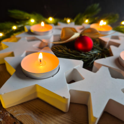 Detailansicht auf ein Teelicht vom Adventskranz mit acht Sternen