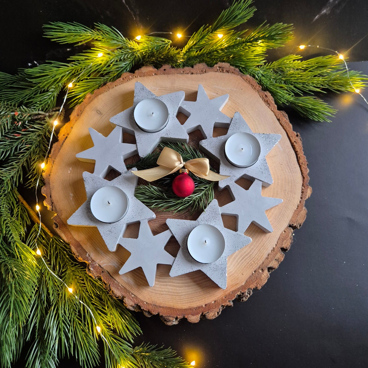 Sicht von oben auf Adventskranz mit Sternen und Teelichtern