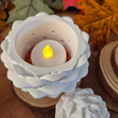 Tannenzapfen aus weißer Gießkeramik mit LED-Teelicht und Lichtlöchern