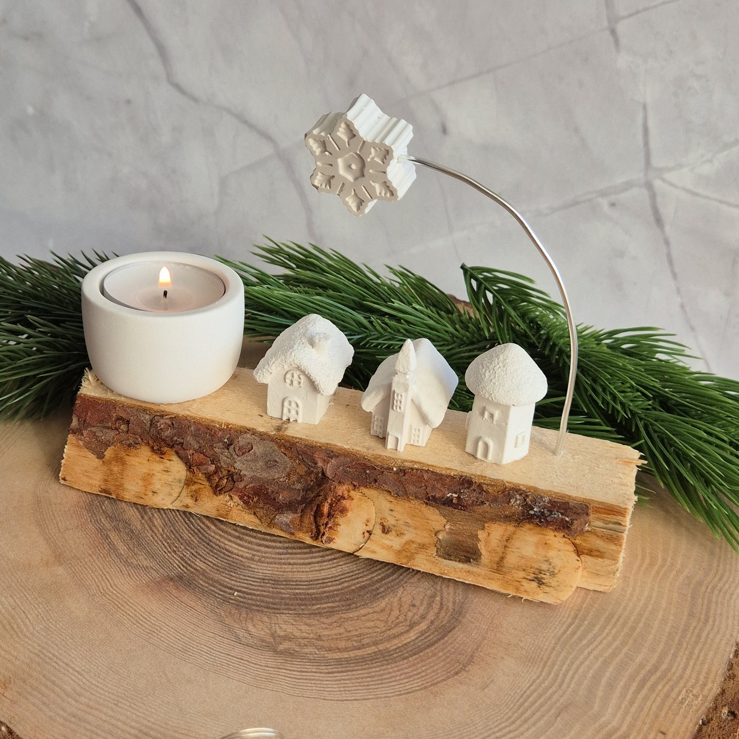 Winterliches auf Holz - verschiedene Häuschen, Bäume und Teelichthalter auf einem Holzschait